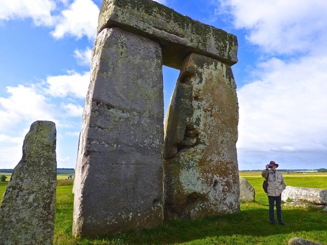 Jack standing next to Stonehenge stone in the early morning.