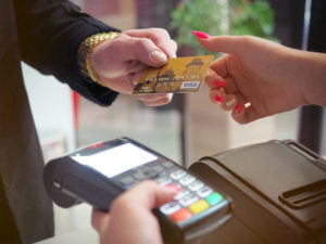 Man handing woman a credit card. Credit cards are a must if you want to avoid problems while traveling.