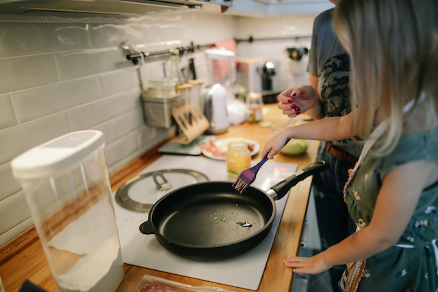 Girl cooking at home with family when they can't travel.