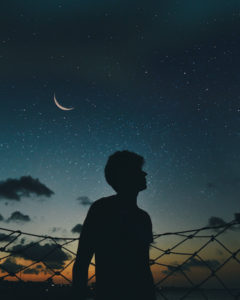 Man outdoors looking at the bright skies with no pollution due to non-travel.