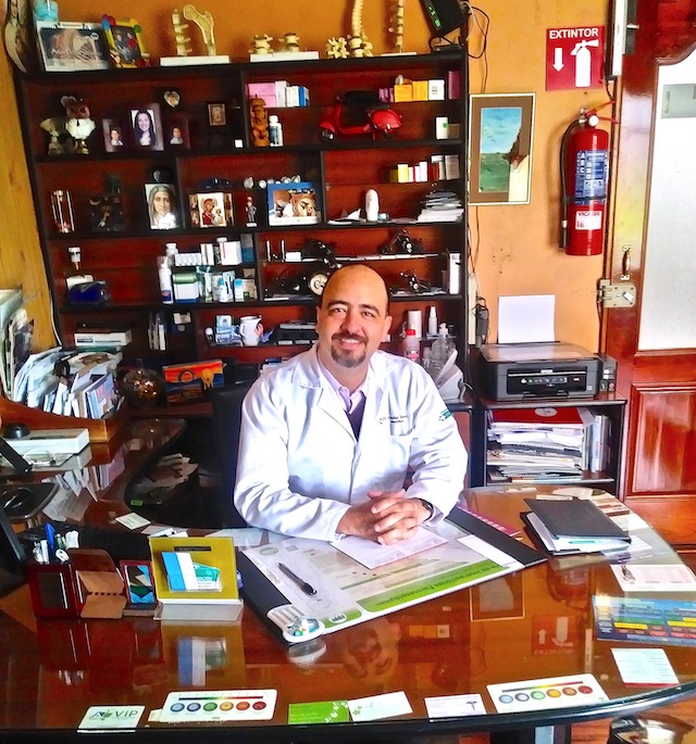 Dr. Gabriel Velez, a health care provider in Cuenca, sitting at his desk.