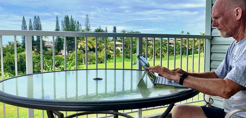 Man sitting typing on computer while on extended travel.