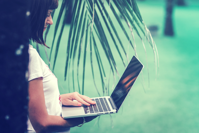 Woman working on computer as a digital traveler 