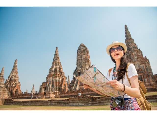 Lady with a map and purse traveling.