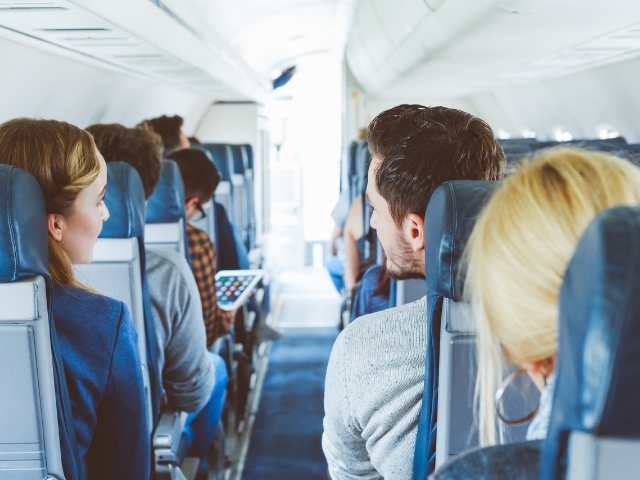 Two Passengers talking about their Delta companion pass on an airplane.  