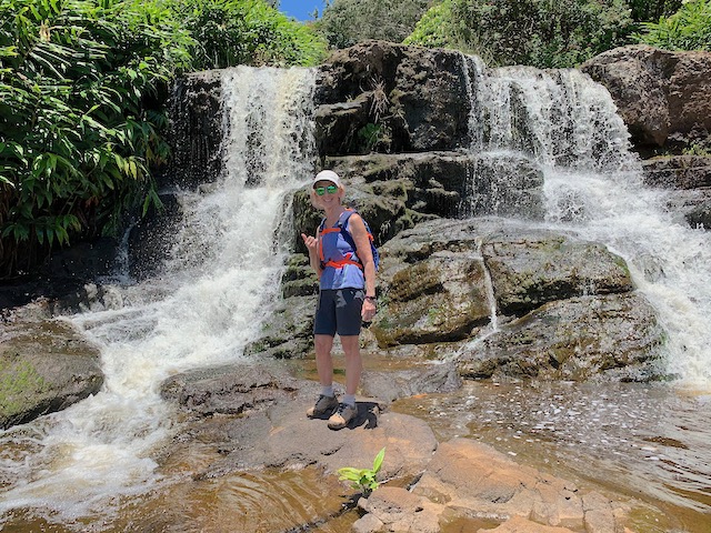 The author standing by a waterfall in Waimea Canyon and Kokee State Park.
