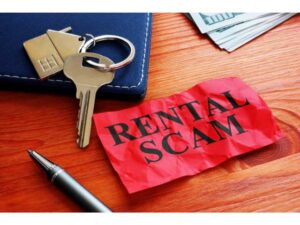 rental scam sign with keys laying on desk