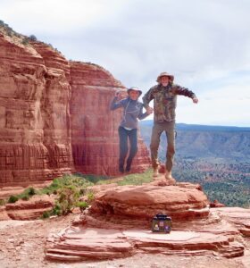 Two people jumping on the top of Bell Rock in Sedona AZ