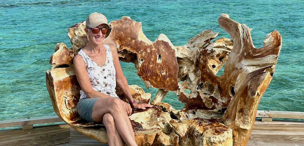 Woman sitting in a chair by the turquoise water in the Maldives