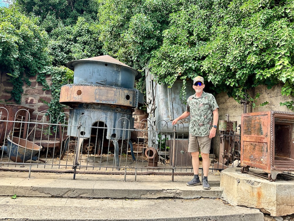 Man with hat standing in front of smelter