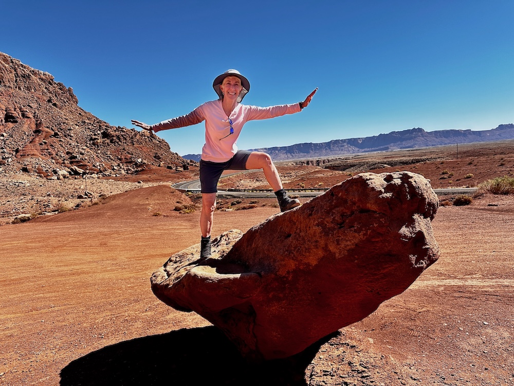 Woman with arms outstretch balancing on a rock