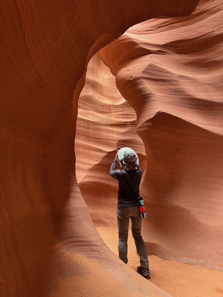 Woman standing in Lower antelope Canyon taking a pciture