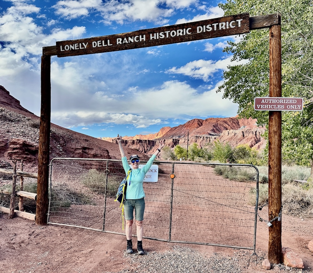 Woman standing in front of the entrance sign to Lonely Dell Ranch in Marble Canyon AZ