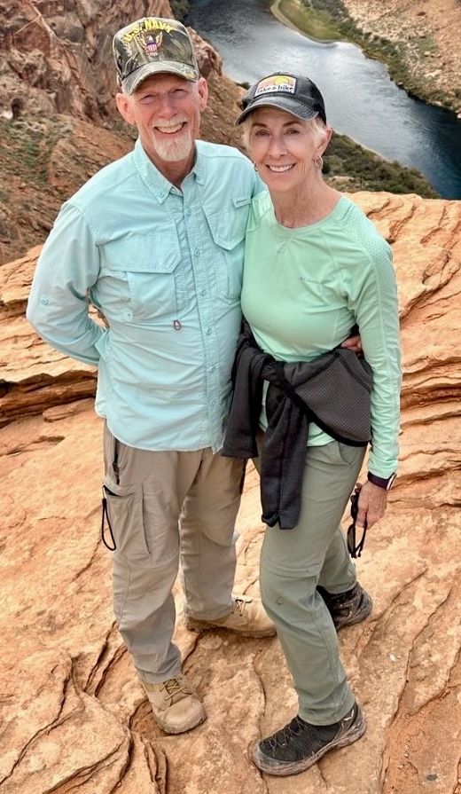 A man and a woman dressed in sunshirt and long moiture wicking pants hiking boots and baseball caps