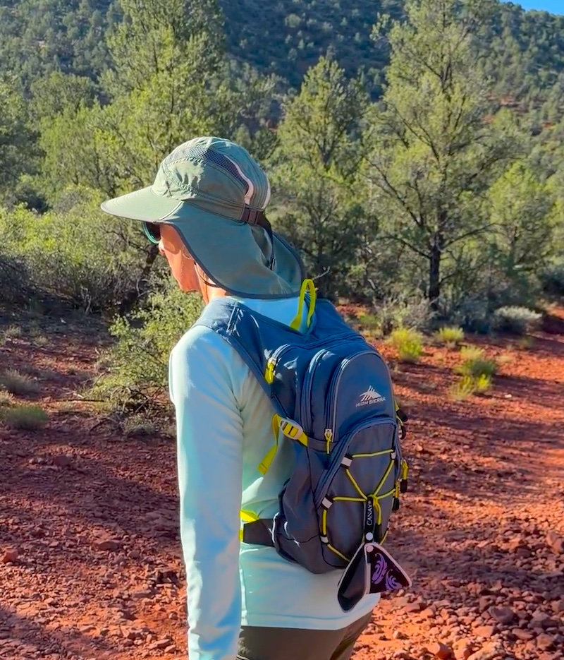 woman wearing a hiking hat and backpack